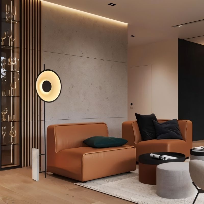 Xyloft Halo Floor Lamp by Residence Supply next to brown leather chairs, showcasing modern design and ambient lighting.