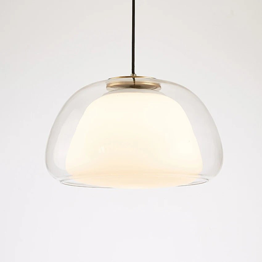 Residence Supply Zabda pendant light with a sleek, modern design and a warm metallic finish hanging from a ceiling.