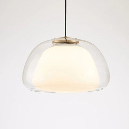 Residence Supply Zabda pendant light with a sleek, modern design and a warm metallic finish hanging from a ceiling.