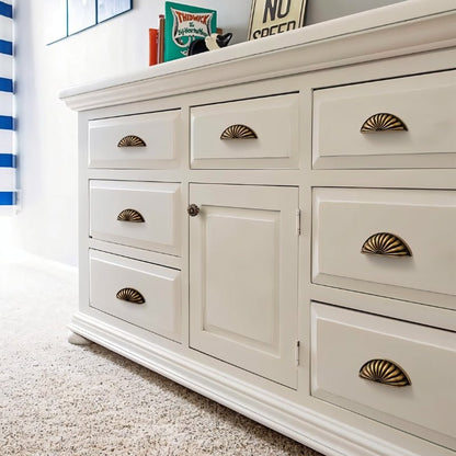 Vintage brass Zintra drawer pull from Residence Supply on a white dresser, showcasing a stylish cabinet hardware design.