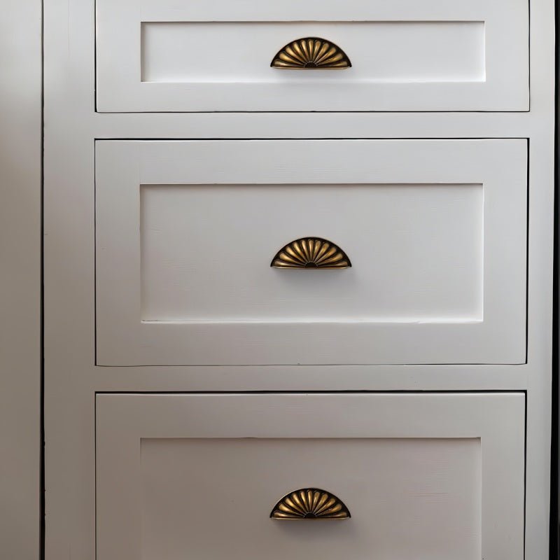 Vintage brass Zintra drawer pull from Residence Supply on a white dresser, showcasing stylish cabinet hardware for furniture.